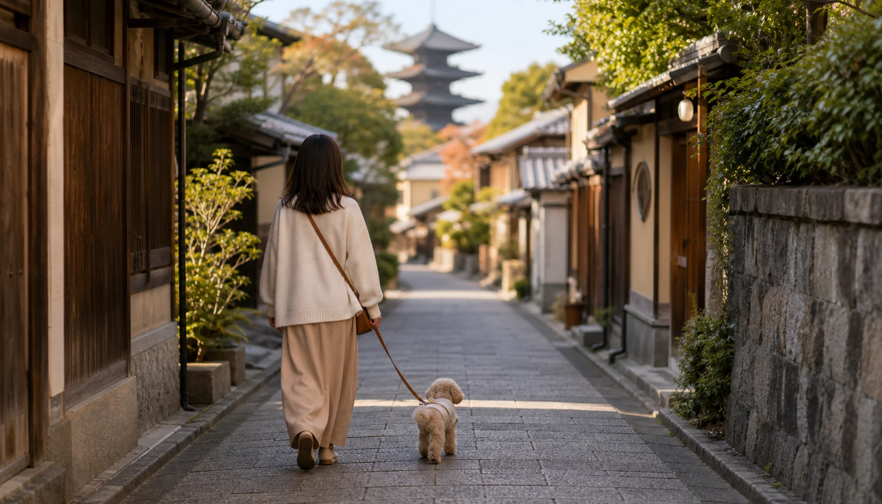 京都の閑静な住宅街を歩く飼い主と小型犬